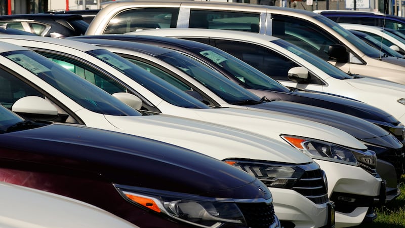 ARCHIVO - Autos a la venta bordean la carretera en un concesionario de autos usados en...