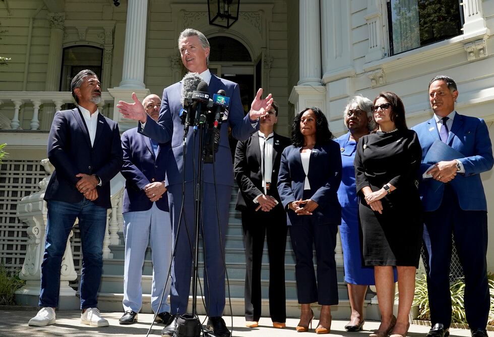 ARCHIVO - El gobernador de California, Gavin Newsom, acompañado por varios miembros de la...